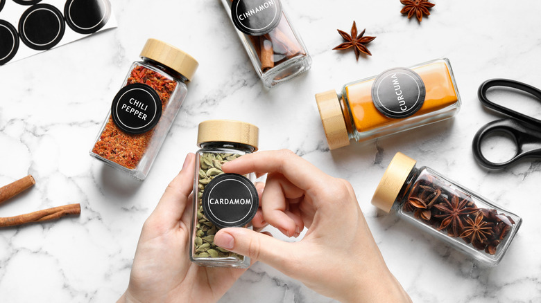 someone adding stickers to spice racks