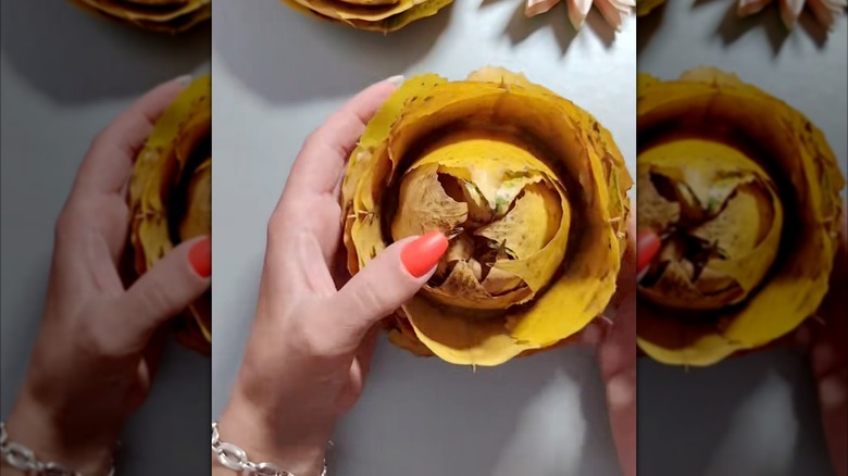 hands holding yellow fall leaf rose