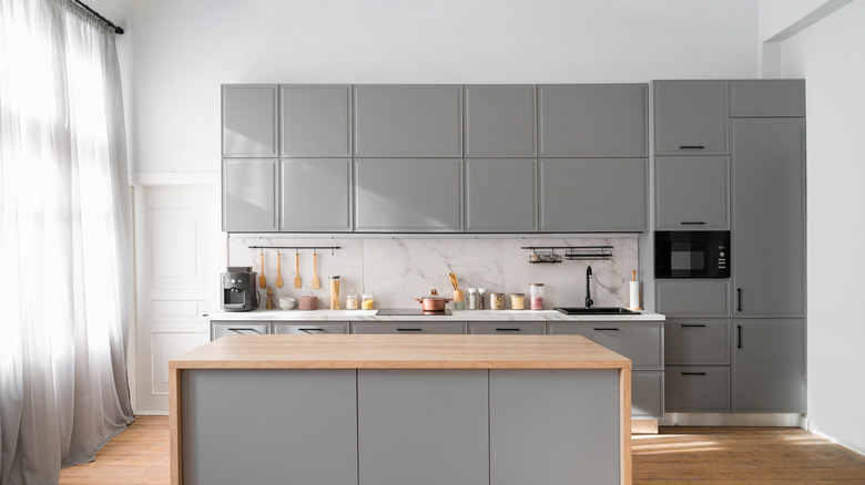 a kitchen with butcher block island and white countertops