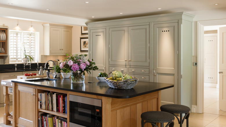 wooden island cabinets with painted cabinets in background