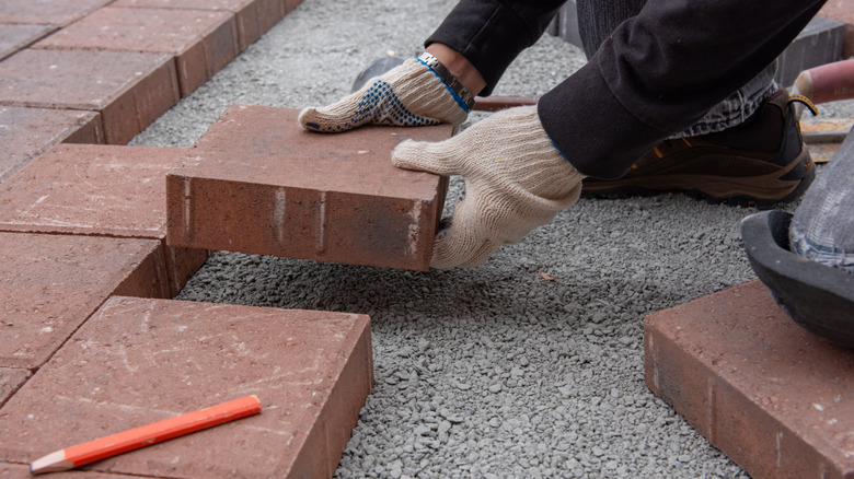 Person installing brick pavers
