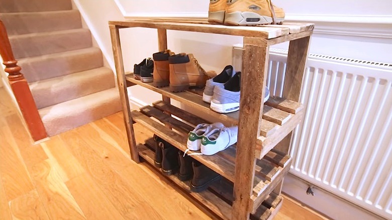 DIY wood pallet shoe rack holding shoes in a home entryway