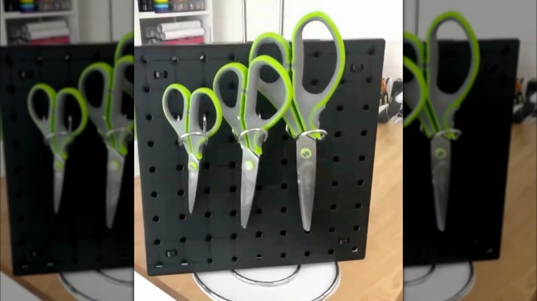 DIY pegboard organizer with three pairs of scissors on it