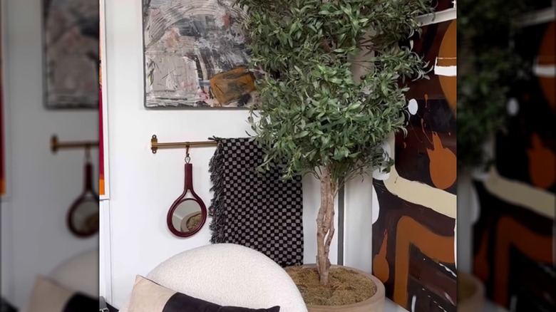 Blanket hanging on an IKEA rail surrounded by artsy wall hangings and decor pieces