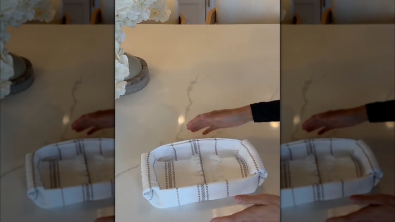 Woman holding a basket made from a kitchen towel