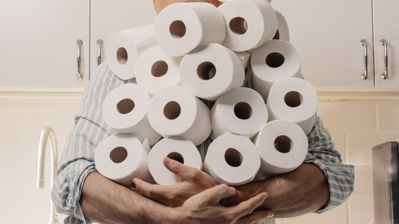 Arms full of toilet paper rolls