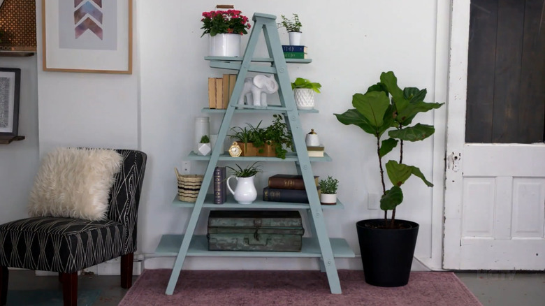 Wood step ladder painted light green with shelves installed and decor on the shelves