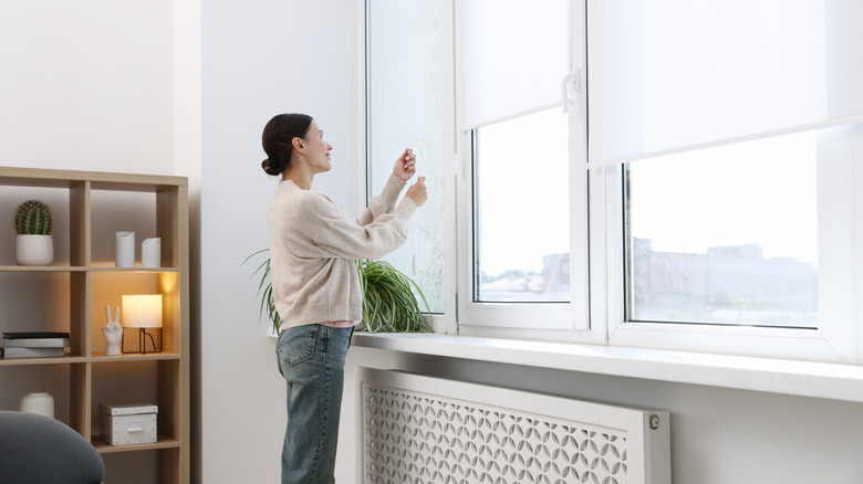 person opening blinds