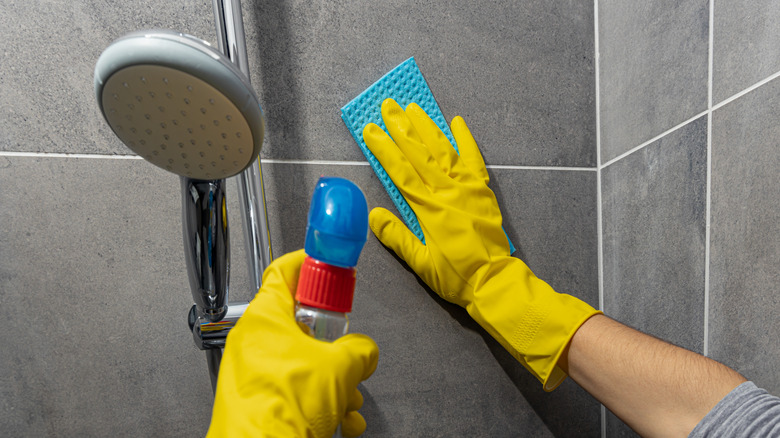 woman cleaning shower walls