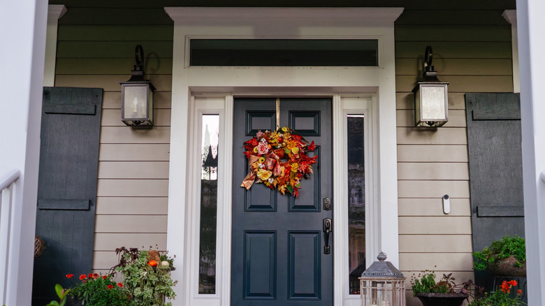 A autum wreath placed on a blue front door