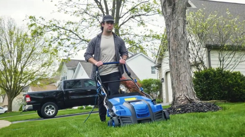 A person using a Westinghouse dethatcher on their lawn