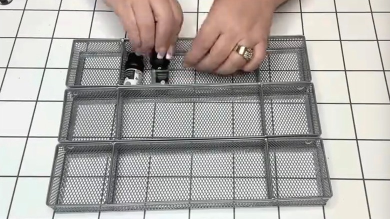 Person arranging small items in DIY organizer made from Dollar Tree
