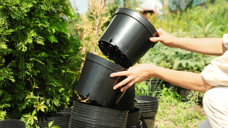 Someone gardening with plastic garden pots