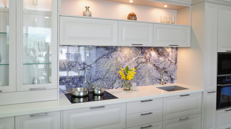 A modern kitchen with an eye-catching blue stone backsplash.
