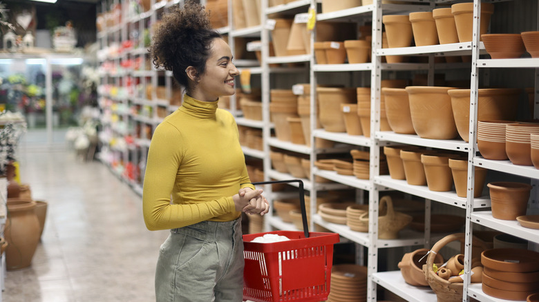 A person browsing planters in a store