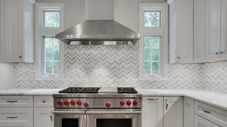 A kitchen with a white and gray tile backsplash