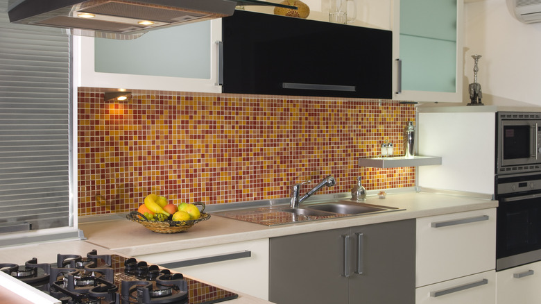 Kitchen with a yellow and red mosaic tile backsplash