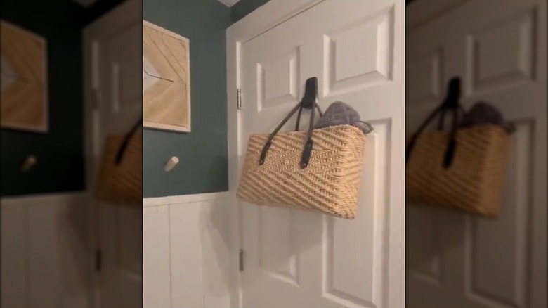 Flexible wicker basket hanging on a Command hook on the bathroom door