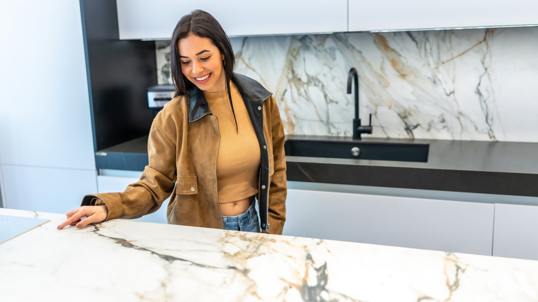 A smiling woman looks at a heavily-veined countertop display