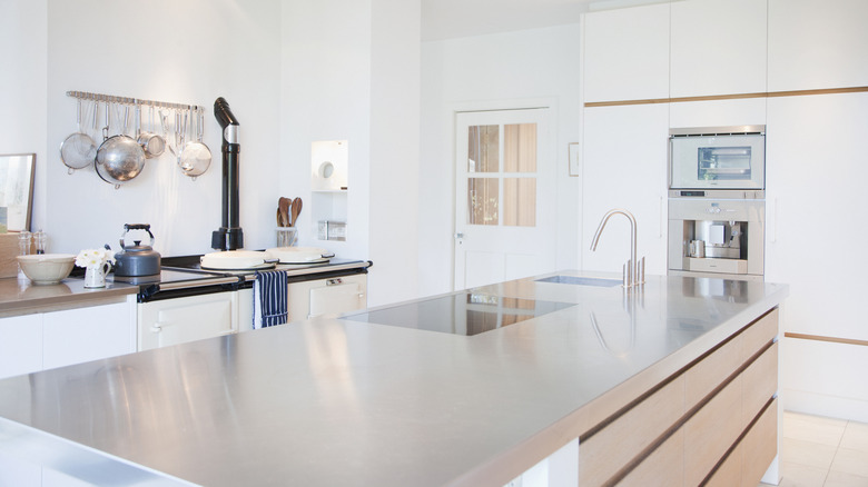 A large white kitchen has stainless steel countertops