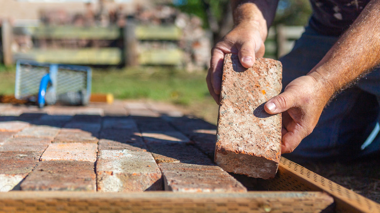 Hand holding reclaimed bricks