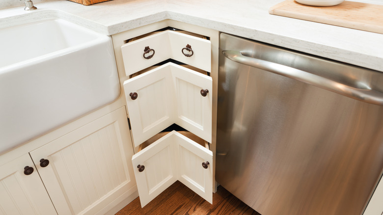 Half-open corner cabinet drawers in white modern farmhouse kitchen