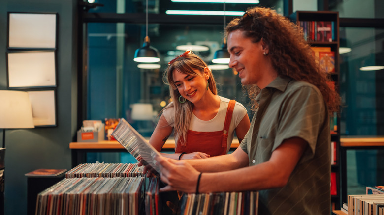 Two smiling young people shop for vinyl records