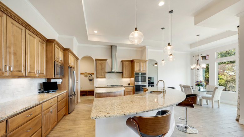 A kitchen with honey oak cabinets and white backsplash tiles
