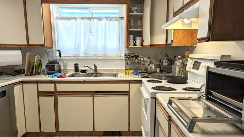 Outdated kitchen with white cabinets