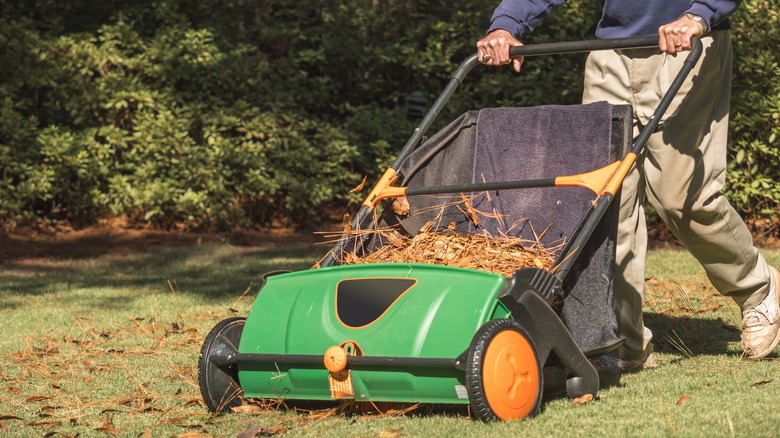 a man using a lawn sweeper