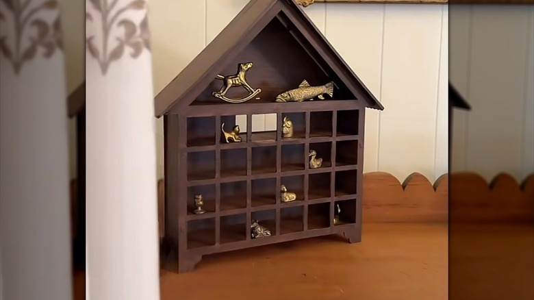 A wooden Advent calendar used as a trinket shelf for brass objects