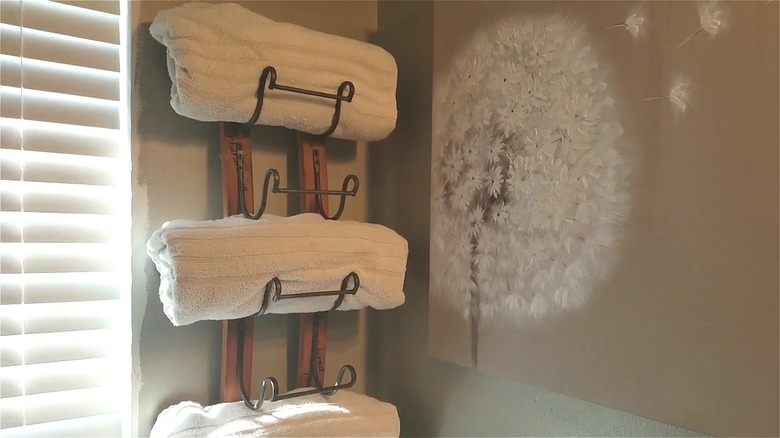 White striped towels rolled and placed on a wine rack