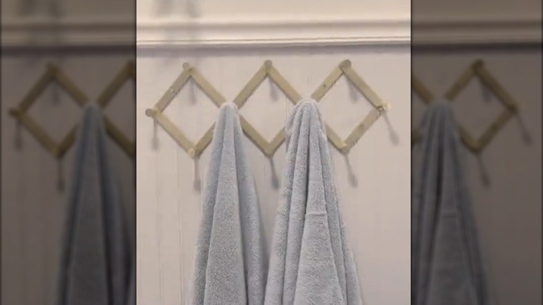 Two towels hanging on an accordion peg rack