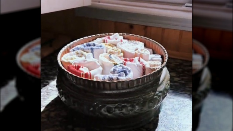 Rolled kitchen towels in a decorative bowl