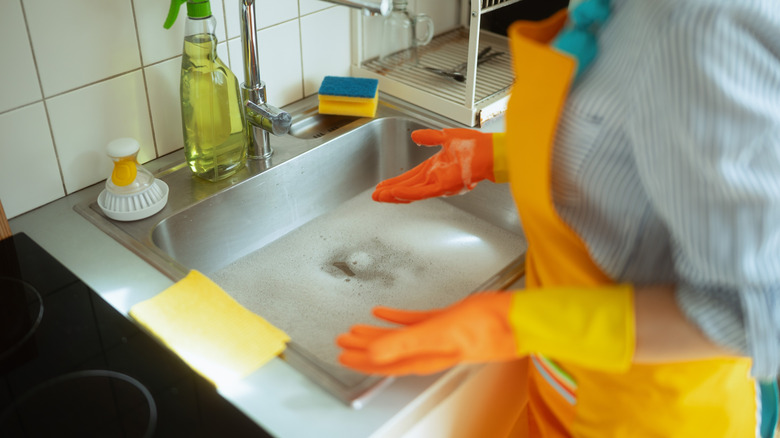 Woman standing at a sink full of water
