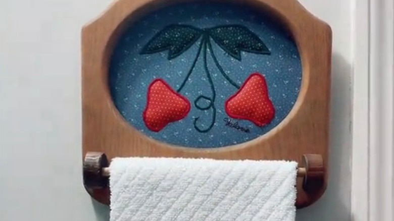 Vintage towel hanger with strawberries on a blue background