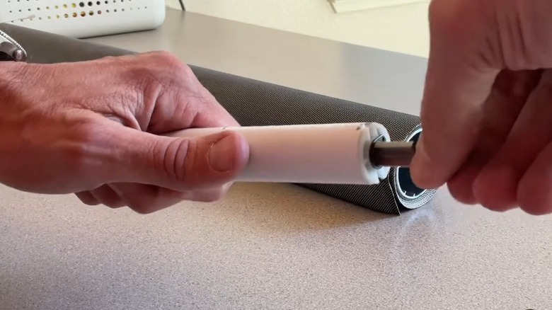 Hands replacing the motor of a motorized roller shade