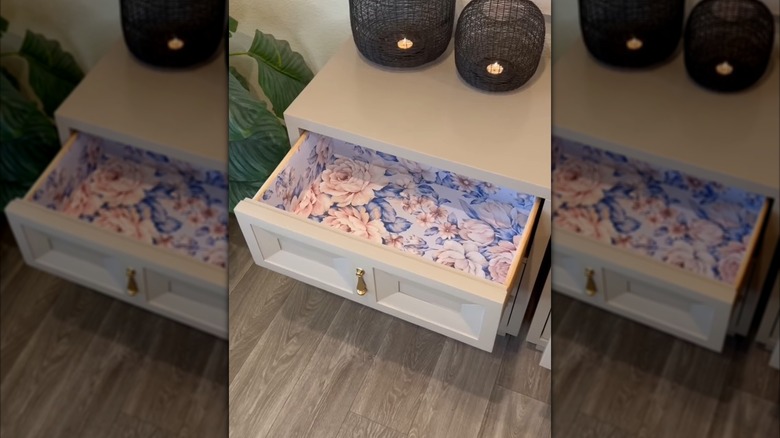 A white cabinet drawer lined with colorful contact paper