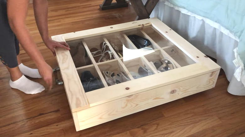 Creator pulling rolling shoe rack with lid out from under the bed