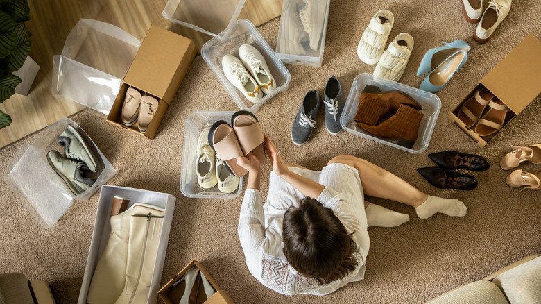 Person sitting on the floor sorting shoes