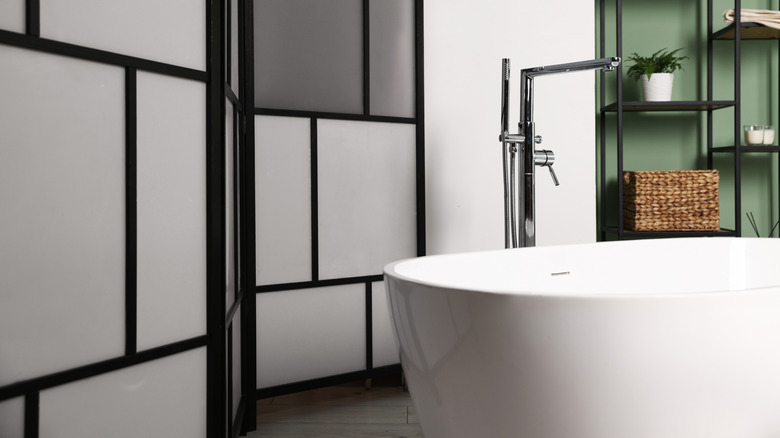 White bathtub with white and gray privacy screen