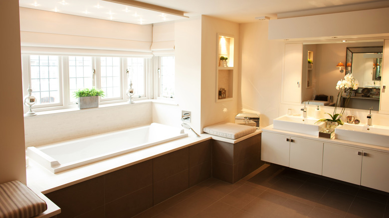 Brown and white bathroom with built in bathtub and no curtain or door