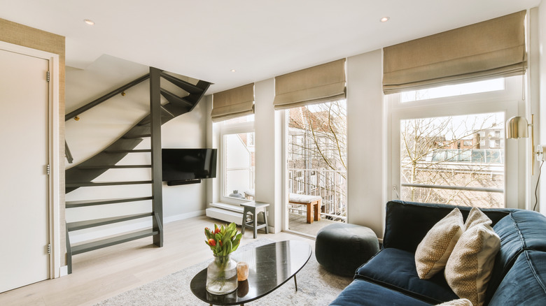 A living room with Roman shades over a sliding door onto a balcony