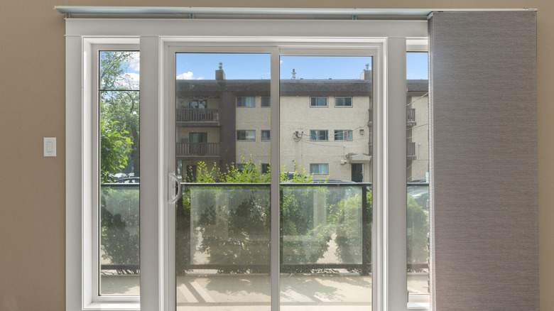 A sliding door with white sliding panels, currently open