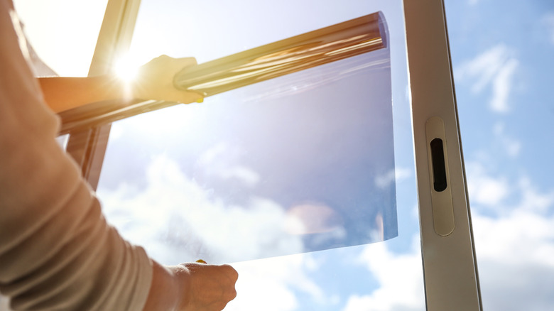 Person applying window film to a sliding door