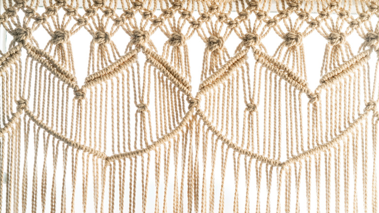 close-up of macrame curtain against white background
