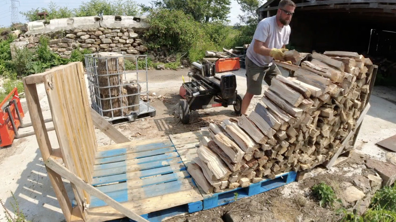 Man stacking firewood on his DIY firewood rack