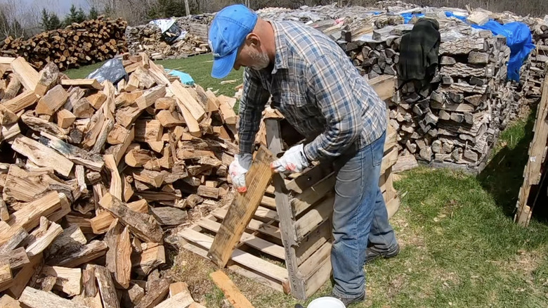 Man building a DIY wood pallet firewood rack