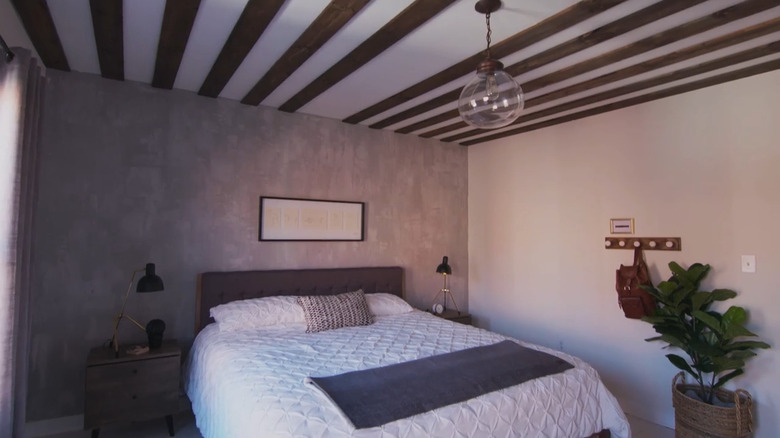 Bedroom with the faux concrete accent wall treatment above the bed