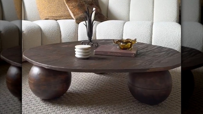 Stylish dark wood coffee table made of IKEA bowls and plywood in front of a white boucle sectional
